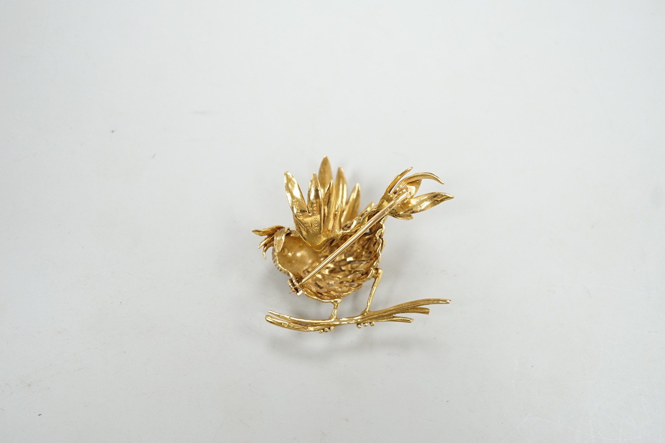 A 1960's Boucheron of Paris 18ct gold and ruby set brooch, modelled as a bird upon a branch, signed, width 43mm, gross weight 20 grams, with Boucheron box.